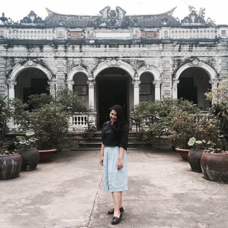 Cô gái trẻ tạo dáng bên căn nhà 